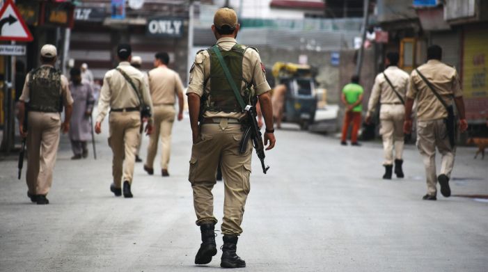 Policemen patrol a road in old city Srinagar on Tuesday